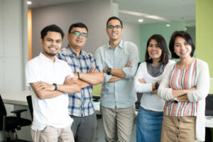 A group of Filipino professionals smiling and standing together in an office setting