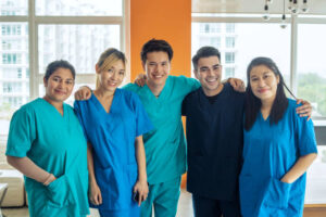A group of Filipino nurses smiling and standing together.
