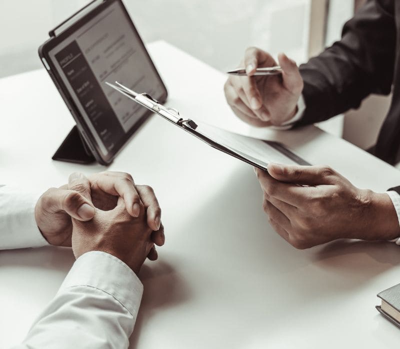 Job interview with two people reviewing a clipboard at a desk