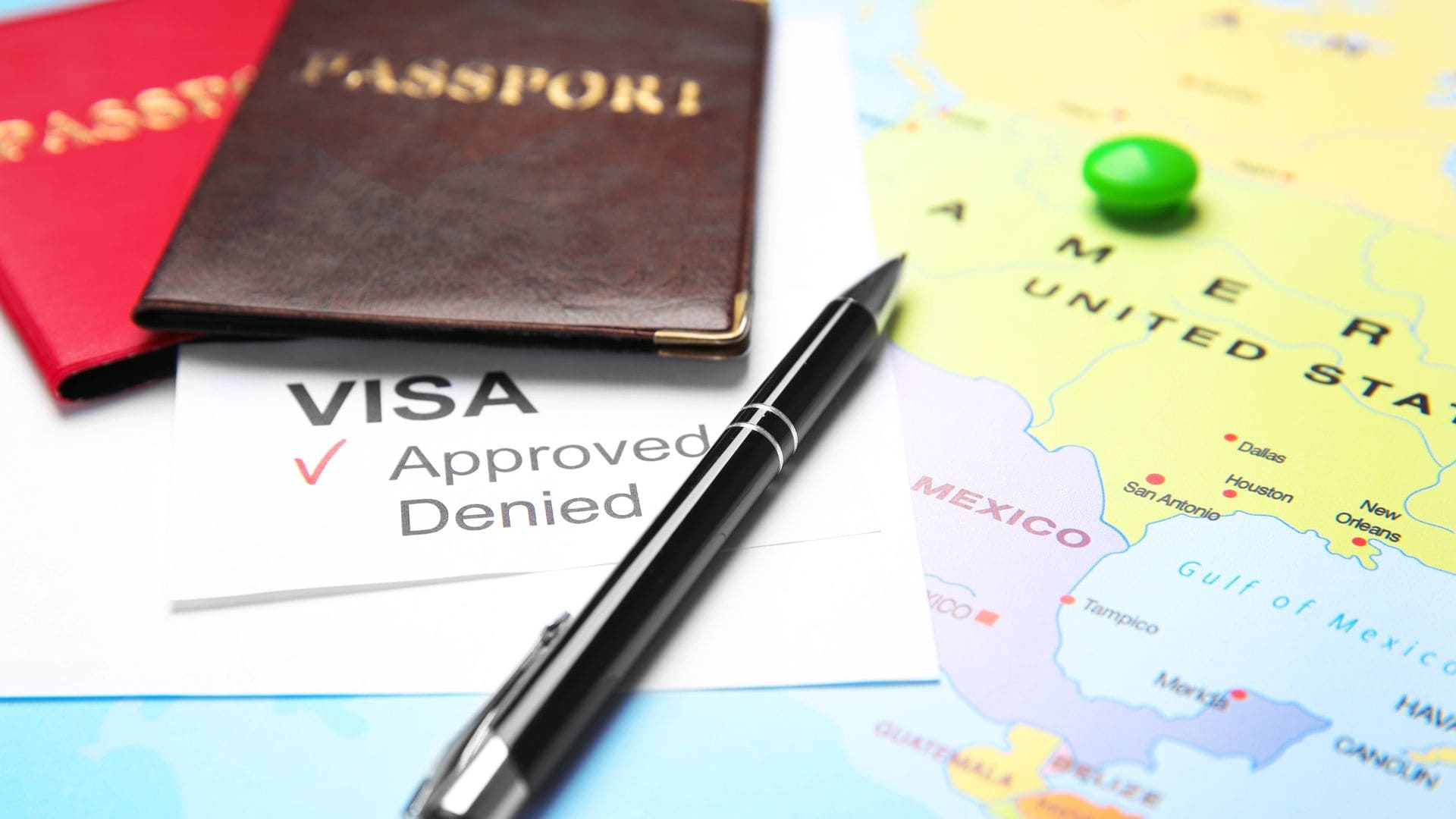 Passports, a visa approval document, a pen, and a map 