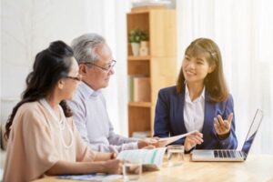 Filipino professional assisting an elderly couple in a discussion.