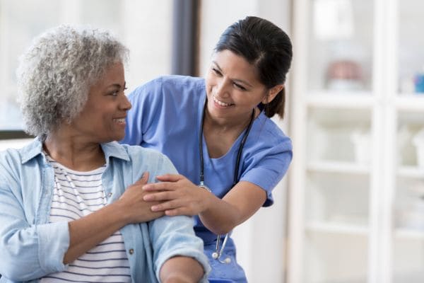 Filipino nurse providing compassionate care to an elderly woman.