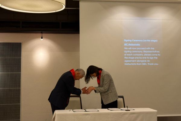 GBA and staffhouse representatives bowing during a signing ceremony.